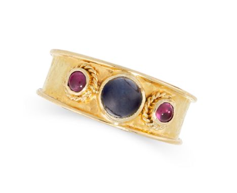 SAPPHIRE AND RUBY RING in 18ct yellow gold, the hammered gold band is set with a cabochon sapphire between two cabochon rubie