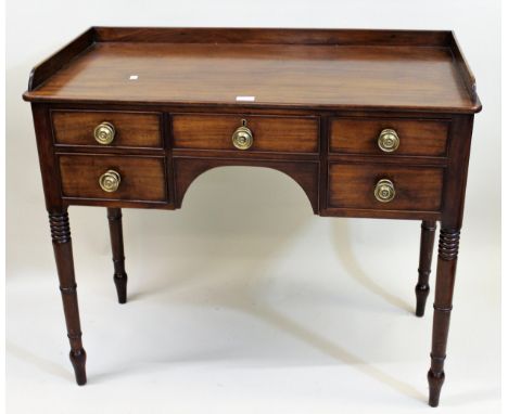 Regency mahogany five drawer side table having kneehole centre and brass knob handles, with ring turned tapering supports, 86