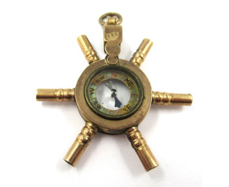 10ct Yellow gold novelty pocketwatch key in the form of a ships wheel with central compass, mounted as a pendant 