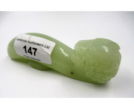 20th Century carved pale green jade belt buckle hook carved with a mask head, character marks to the base, 11cm wide 