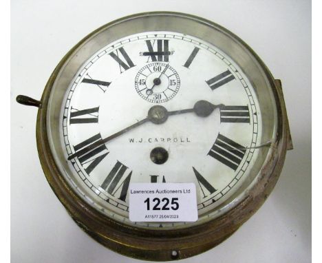 Circular brass ships bulkhead clock, the enamel dial inscribed 'W.J. Carpoll', with roman numerals and subsiduary seconds and