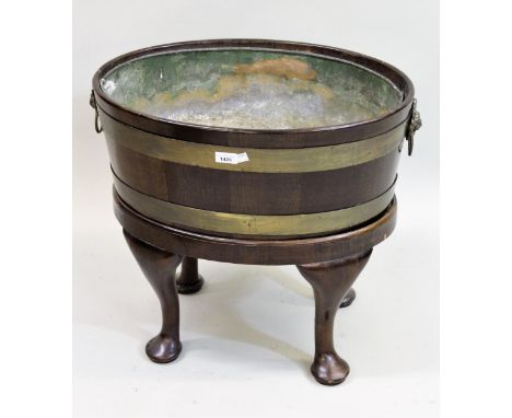 19th Century mahogany oval brass bound wine cooler in George III style, with lion mask ring end handles above a  moulded frie