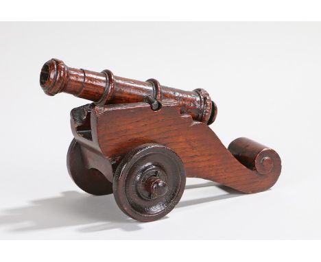 Charming George III period carved oak cannon, loose mounted on a carriage with one step, scroll to the rear and with solid wh