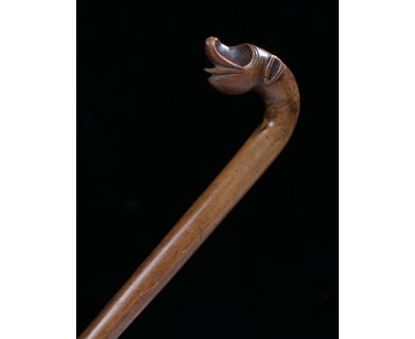 African hardwood walking stick, the curved handle carved with depiction of a stylised animal, with tapering shaft, 84.5cm lon