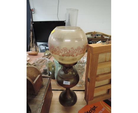 A brass oil burning lamp with etched and colour shade