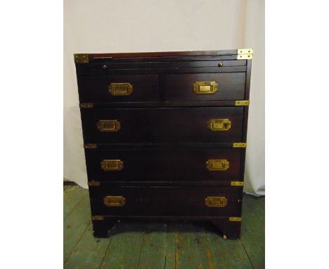 A rectangular mahogany brass bound campaign chest of drawers with inset handles and hinged top on four bracket legs