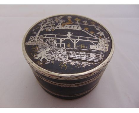 A white metal circular double sided trinket box, decorated with oriental themes to both pull-off covers