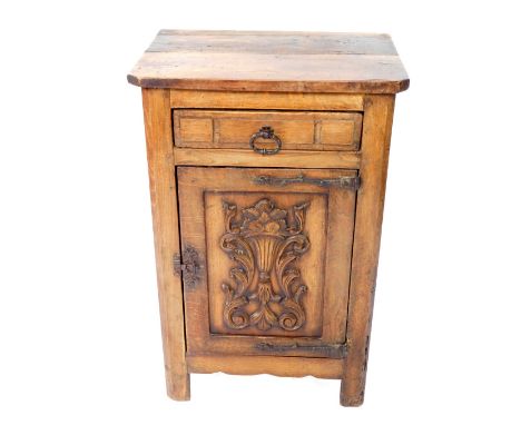 An oak pot cupboard, with a canted rectangular top, over a frieze drawer, above a carved panelled door cupboard, enclosing a 