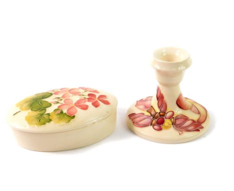 A Moorcroft pottery oval box and cover, decorated in the Pink Geranium pattern, impressed marks, 13cm W, together with a cand