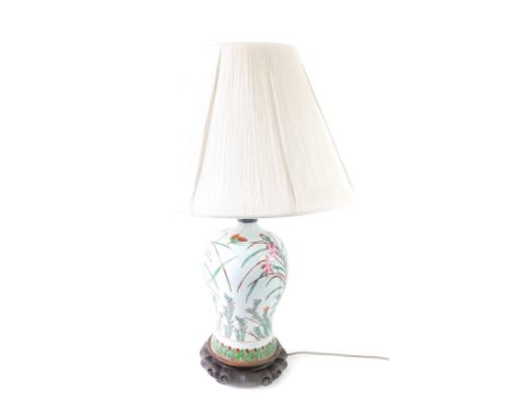 A Chinese famille rose porcelain table lamp, of baluster form with floral decoration against a pale celadon ground, raised on