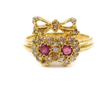 An 18ct ruby and diamond sweetheart ring, comprised of two conjoined hearts surmounted by a bow, size L/M, 4.2g.