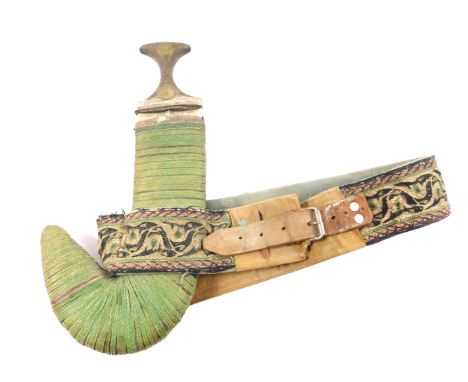 A Yemeni Jambiya, the horn hilt with metal embellishments, double edged steel blade and Asib leather and woven bound, on a wo