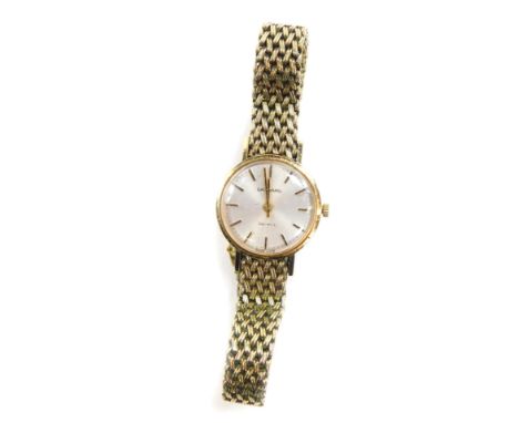 A Garrard lady's 9ct gold cased wristwatch, circular silver dial with gilt batons, on a gold plated mesh bracelet and snap cl