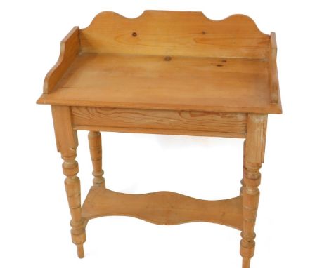 A Victorian pine washstand, with a galleried top, raised on turned and fluted legs united by stretchers with a shaped under s