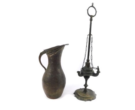 A 19thC brass oil lamp, of Roman oil lamp form, with long carrying handle, the body with three apertures, raised on a serpent