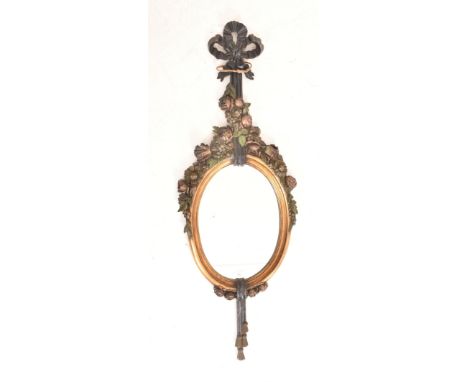 An Italian toleware inspired 20th century carved wall hanging mirror. The mirror having a bobbin shaped top over intricately 