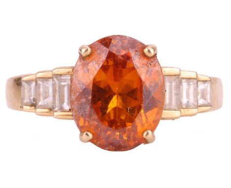 An orange garnet and diamond ring in 18ct gold; the oval-cut garnet of 10.4 x 8.4 x 6.5 mm, in four claw out above tiered sho