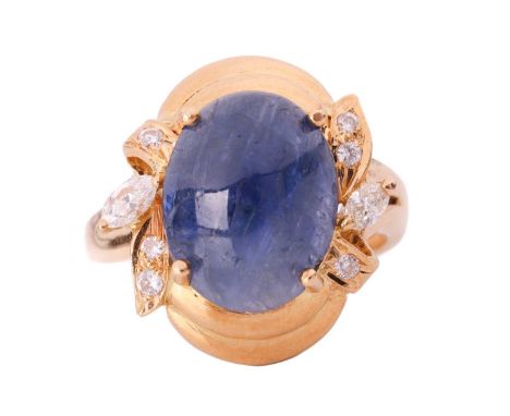 A sapphire and diamond ring; the oval cabochon sapphire approximately measures 13.2 x 10.5 x 5.2 mm, in a stylised foliate mo