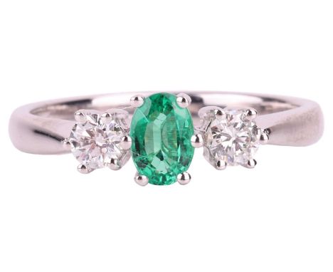 An emerald and diamond trilogy ring in 18ct white gold, centred with an oval-cut emerald of light bluish-green, approximately