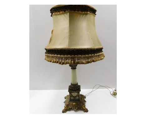 An early 20thC. decorative lamp with ornate gilt fittings over onyx with original shade, lamp 19in high, with shade 30in high