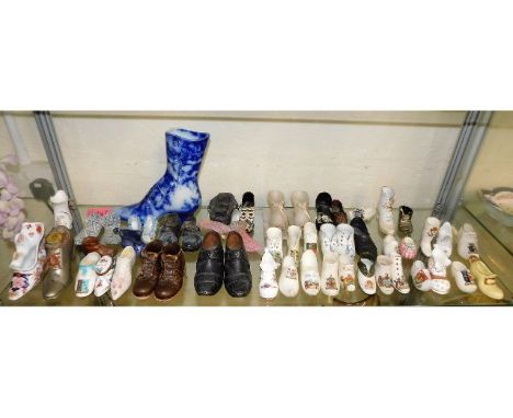 A large collection of mostly porcelain shoes, contents of shelf, including a small child's hobnail leather pair 