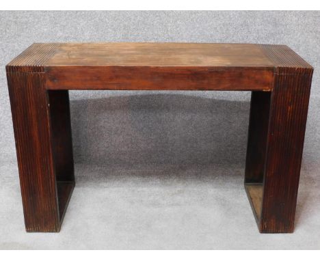 An Eastern hardwood console table with reeded block supports. H.77 W.120 D.45cm 