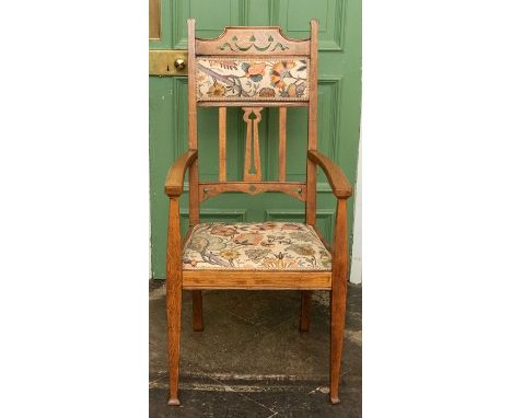 An Arts &amp; Crafts light oak carver armchair, circa 1905, upholstered and fret carved back with stylized heart motifs, upho