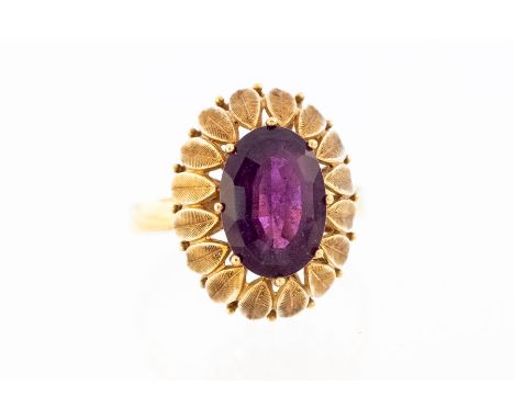 A 14ct amethyst dress Ring, claw set oval-cut amethyst, approx. 12mm x 9mm in textured ‘flower petal’ mount, 8.0g