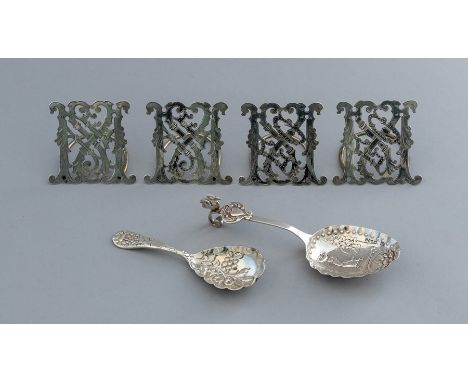 A set of four late 19th Century white metal place name or menu holders, pierced monogram design, (unmarked), with two silver 