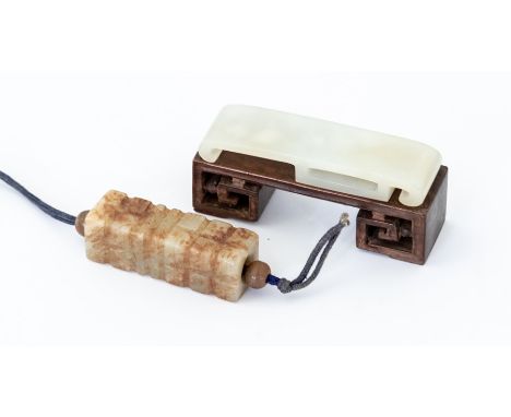 A white jade Sword Slide, approx. 75mm long with carved hardwood stand together with a white and russet jade toggle, carved t