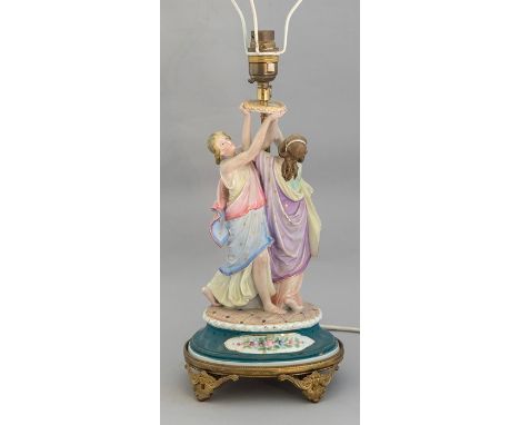 An early 20th Century continental tinted bisque table lamp, in the form of two classically draped maidens, cast brass mounts,