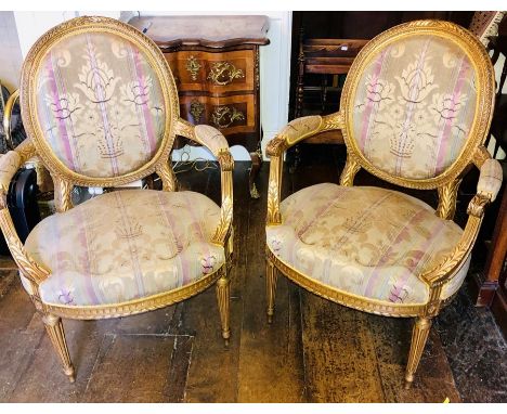 A Louis XVI revival giltwood three piece salon suite, comprising two seater sofa, two armchairs, all oval spoon back united w