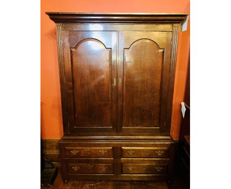 A mid 18th Century George II/III oak livery cupboard, circa 1760, moulded cornice over two arch panel doors flanked by fluted