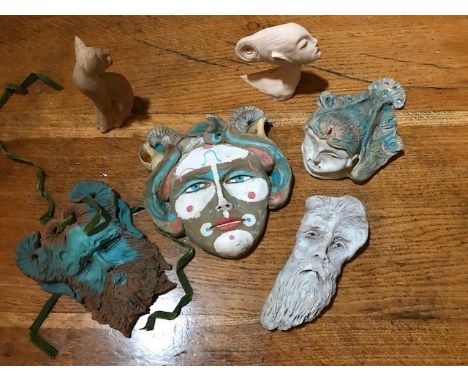 George Jardine (British,1920-2003), four ceramic face masks and a female head, together with a wooden seated cat, height of l