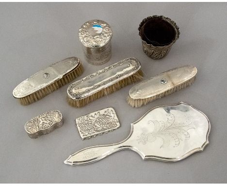 A collection of assorted Victorian silver dressing table wares, mainly repousse decorated, to include a cosmetic jar, a serpe