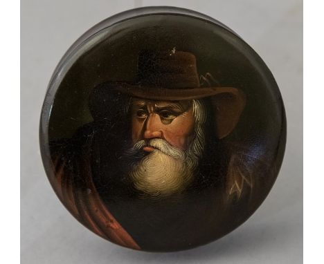 A 19th Century Stobwasser circular lidded table snuff box, the cover decorated with a bearded gent wearing a hat, the inner c