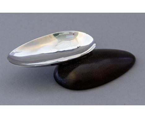 A mid 20th Century white metal pebble shaped trinket dish, hardwood base, no obvious marks, width 14cmCondition: good overall