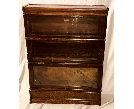 A 1920's Globe Wernicke Co Ltd library stacking book case, being a stack of three shelves with cornice and base, each shelf s