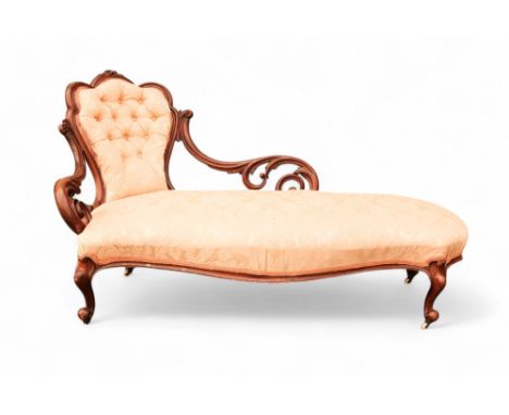 A Victorian walnut and upholstered chaise longue - the button upholstered back with pierced foliate supports and raised on sh