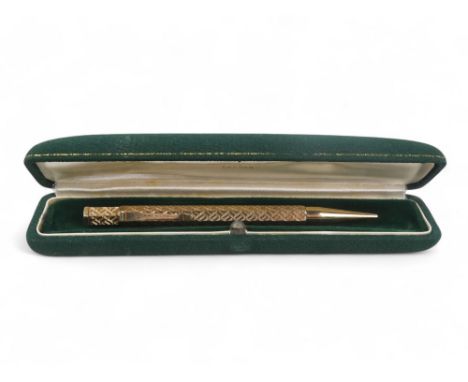 A 9ct gold pencil - hexagonal with engine turning and a vacant cartouche, retailed by Wilson &amp; Gill, 25.3g gross.
