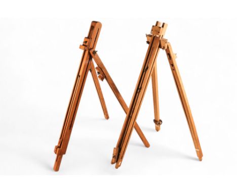 A 20th century beech travelling easel - with brass fittings, together with another similar. (2)