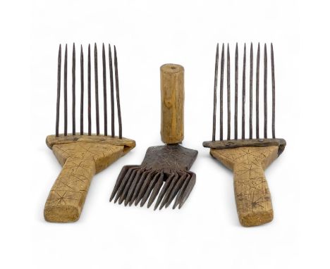 A pair of teasing combs - the tines set in horn and mounted on wooden handles, together with another wrought iron teasing com