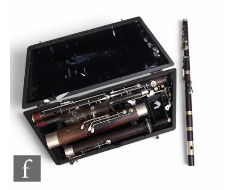 A late 19th or early 20th Century bassoon in four sections, nickel plated mounts, unnamed, cased, and a four sectional flute.