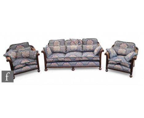 An early 20th Century carved mahogany framed three piece bergere lounge suite, with single bergere panel sides and backs, com