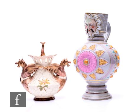 A Vienna majolica mask jug, circa 1880, of footed spherical form with drawn mask moulded collar, the body with relief moulded