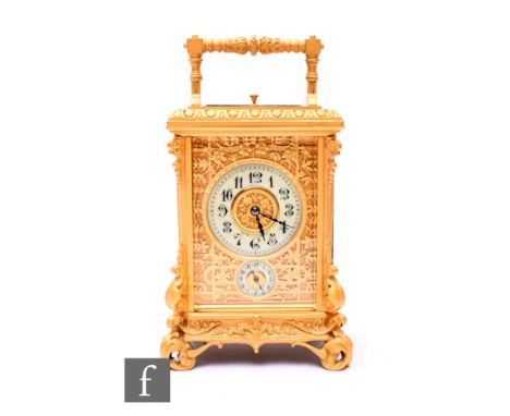 A late 19th to early 20th Century French gilt carriage clock, Arabic dial and second subsidiary dial and pierced floral surro
