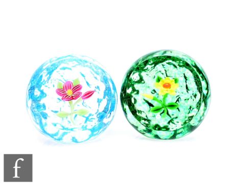 A contemporary William Manson glass paperweight, internally decorated with a spray of stylised lamp work flowers and buds in 