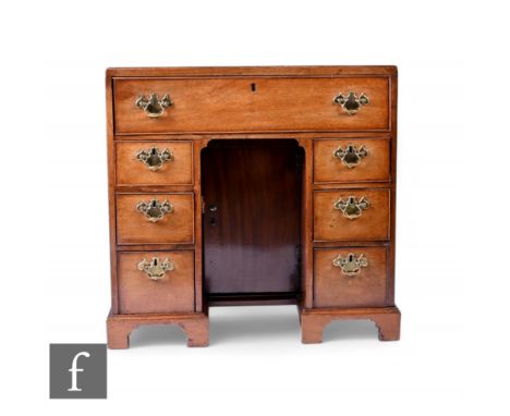 A George III crossbanded mahogany kneehole desk of small proportions fitted with a single long drawer and three drawers to ea