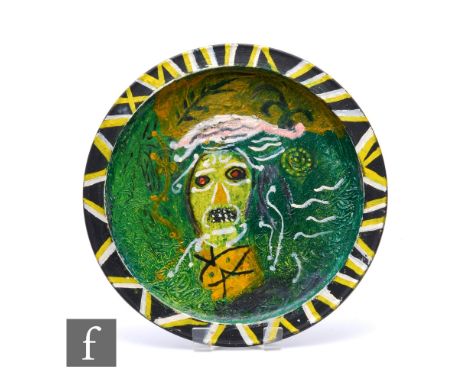 A large studio pottery charger, circa 1975, hand painted with a grotesque portrait, signed and dated, diameter 42.5cm.
