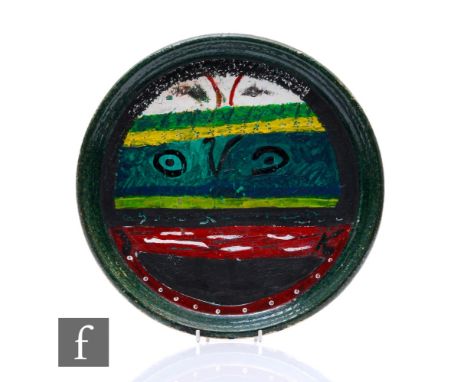 A studio pottery charger, circa 1970s, decorated with an abstract face with bands of colour, the reverse used as a palette, d